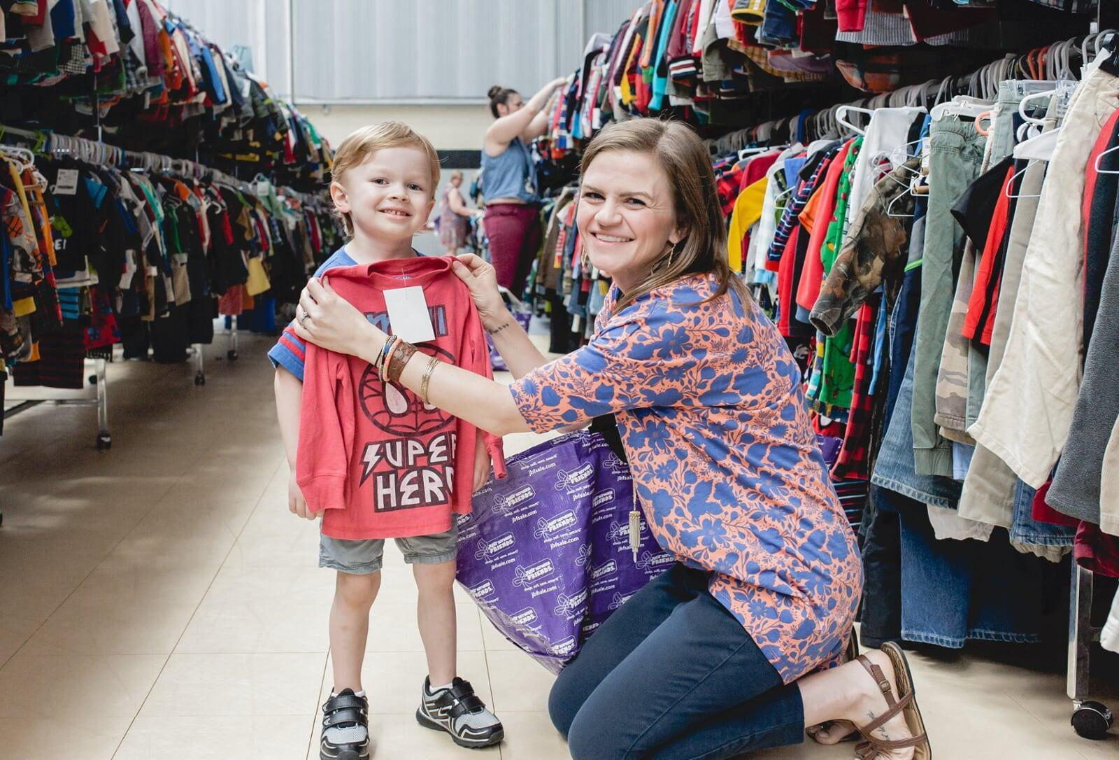 A mother and daughter stand side by side in their masks as they shop their local JBF sale.